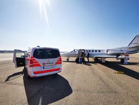 Ein Rettungsdienstwagen bei der Übergabe am Flughafen