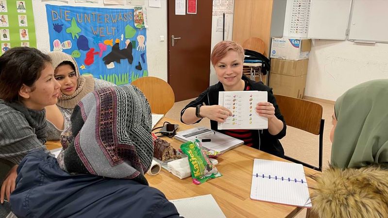Eine Ehrenamtliche gibt den geflüchteten Frauen Deutschunterricht