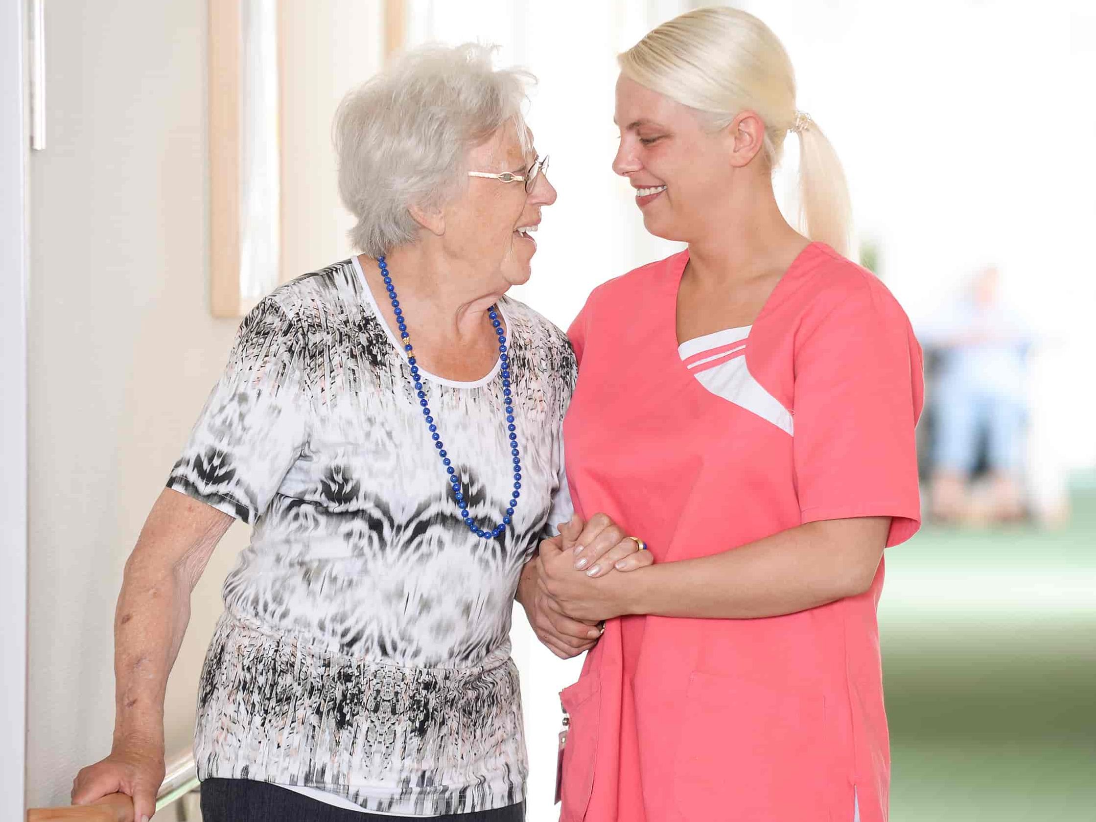 Eine ältere und eine jüngere Frau lachen sich an.