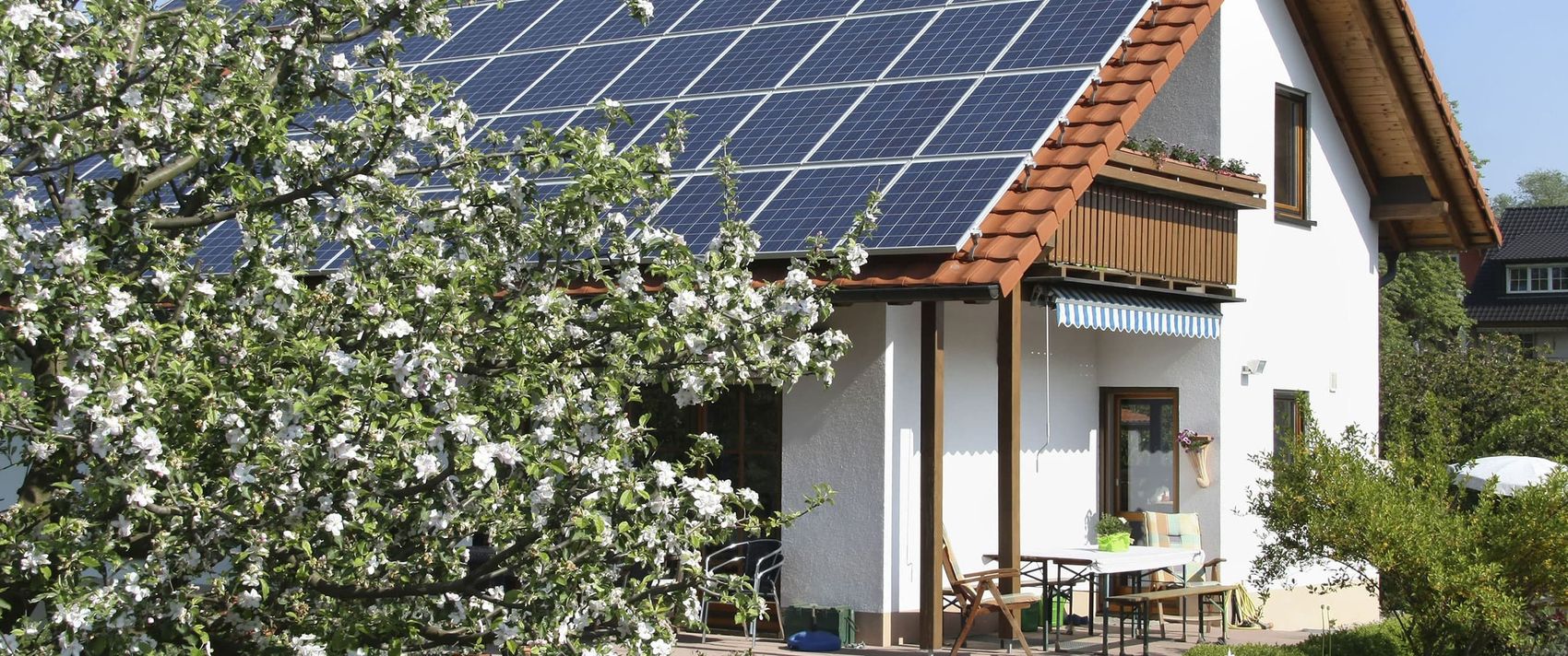 Haus mit schönem Garten und Solarzellen auf dem Dach