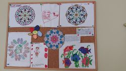 Auf einer Pinwand sind von Kindern gemalte Zeichnungen zu sehen.