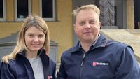 Eine Frau und ein Mann in Malteserjacken stehen nebenenander.