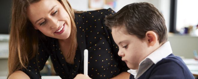 Eine Frau hilft einem Kind beim Lernen. 