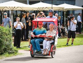 Christian Wulff fährt Fahrgäste mit einer Malteser Rikscha