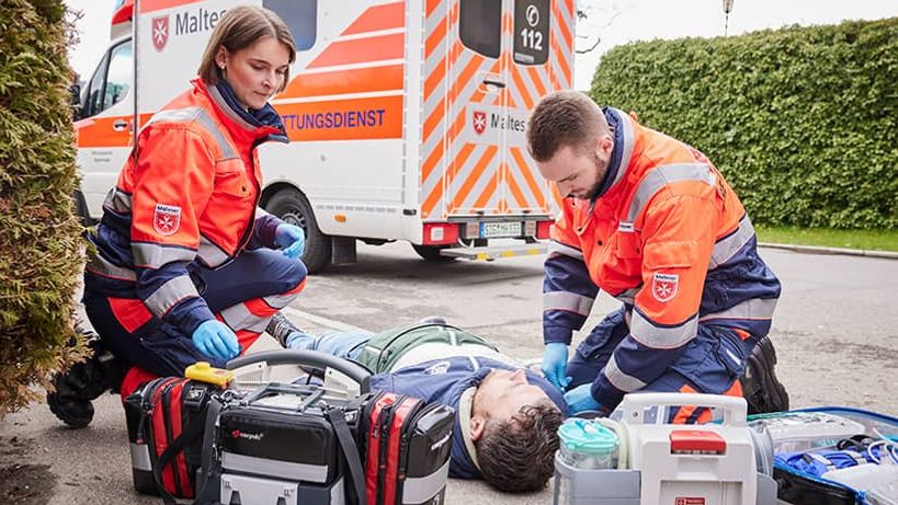 Eine Rettungssanitäterin und ein Rettungssanitäter versorgen einen Verletzten.