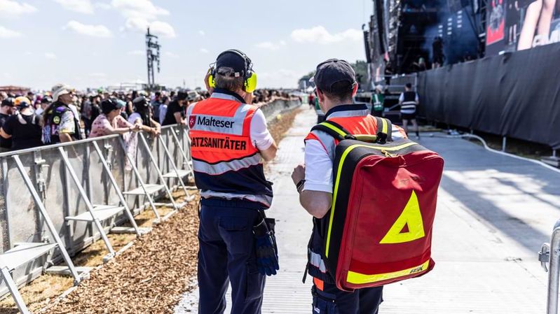 Zwei Sanitäter im Bühnengraben eines Festivals. 