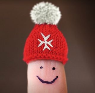 Finger mit lachendem Gesicht trägt Mütze