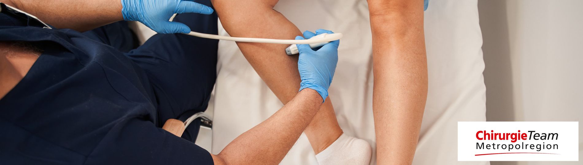 Ein Arzt führt einen Ultraschall zur Untersuchung der Venen am Bein einer Patientin durch.