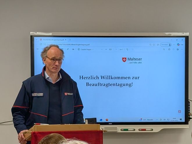 Diözesanleiter Dr. van Lengerich eröffnet die Tagung vor einem Smartboard das "Willkommen zur Beauftragtentagung" anzeigt
