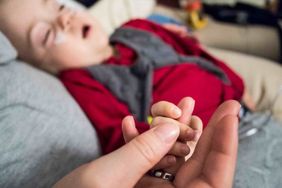 Betreuer hät Hand von schwer krankem Kind