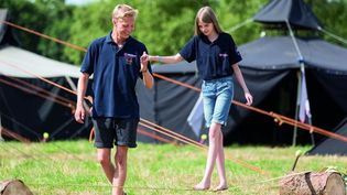 Ein Mitarbeiter der Malteser Jugend spielt mit einem Mädchen im Grünen.