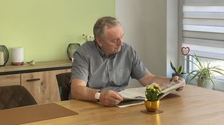 Ein Senior mit einem Hausnotruf-Armband beim Zeitunglesen