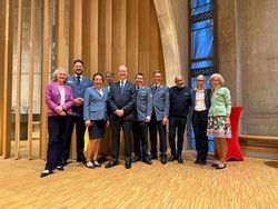 Gruppenfoto im Malteser Campus St. Maximilian Kolbe in Hamburg. Zehn Personen stehen nebeneinander vor einer Holz- und Kirchenarchitektur mit hohen Fenstern. In der Mitte steht Großhospitalier Dr. Josef D. Blotz, flankiert von weiteren Teilnehmenden der Veranstaltung. Von links nach rechts: Daisy Gräfin von Bernstorff, Malte Rohe, Susanne Behem-Loeffler, Philippe Prinz von Croÿ, Dr. Josef D. Blotz, Christoph Wolloscheck, Benjamin Borngräber, Moustafa Masoud, Claudia Berns und Monika von Detten.