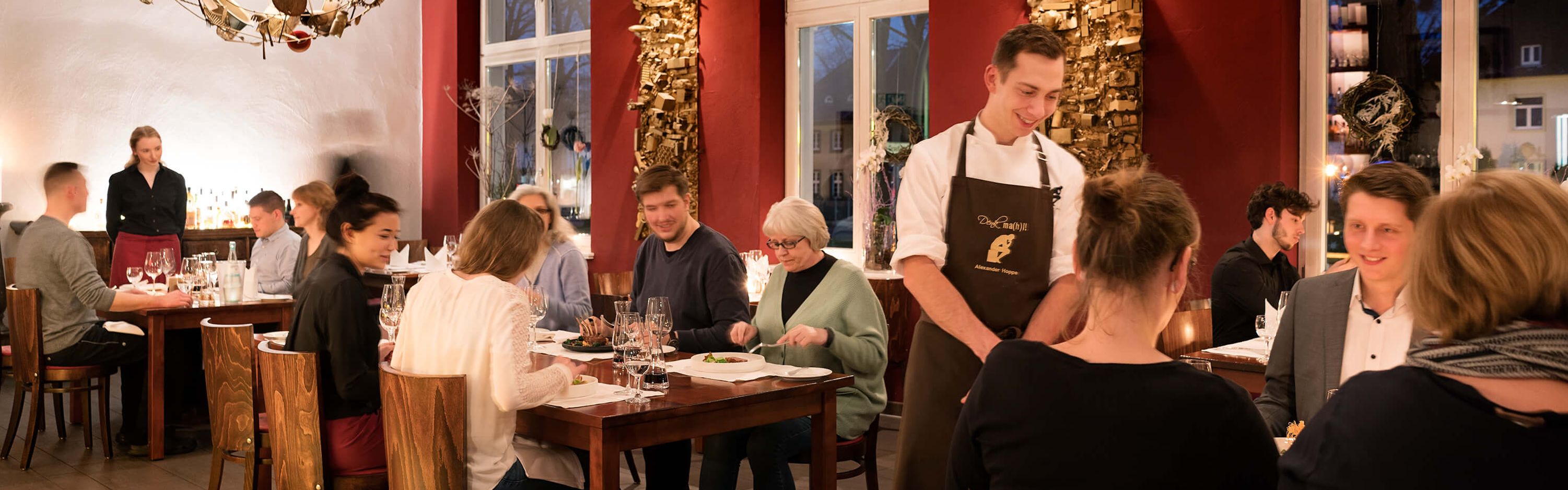 Koch unterhält sich mit Gästen im Restaurant