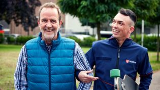 Mann und Malteser Helfer gehen gemeinsam spazieren