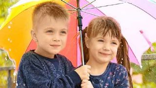 Zwei Kinder unter einem Schirm