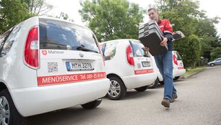 Menüservice Fahrdienstmitarbeiter der Malteser liefert Essen aus.