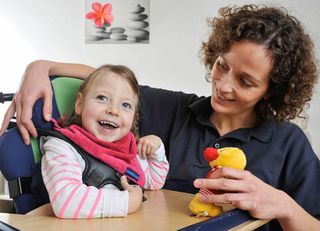 Eine Hospizbegleiterin mit einem lachenden Kind