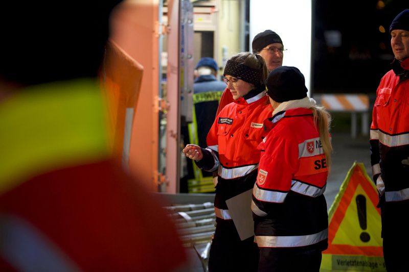 Junge Frau in Sanitäteruniform bespricht sich mit Kollegin.