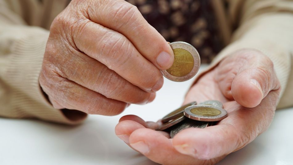 Eine Hand, in der mehrere Zwei-Euro-Geldstücke liegen.