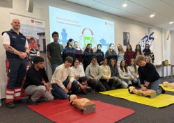 Schülerinnen und Schüler üben an Reanimationspuppen Wiederbelebung.