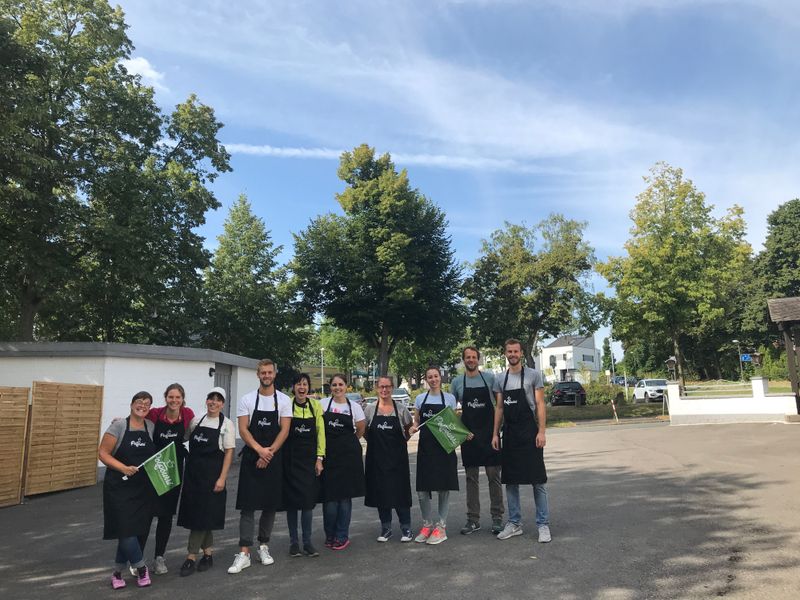 Das Team von Potpourri mit Schürzen und Fähnchen