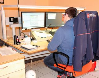 Ein Einsatzleiter vor zwei Bildschirmen an einem Schreibtisch