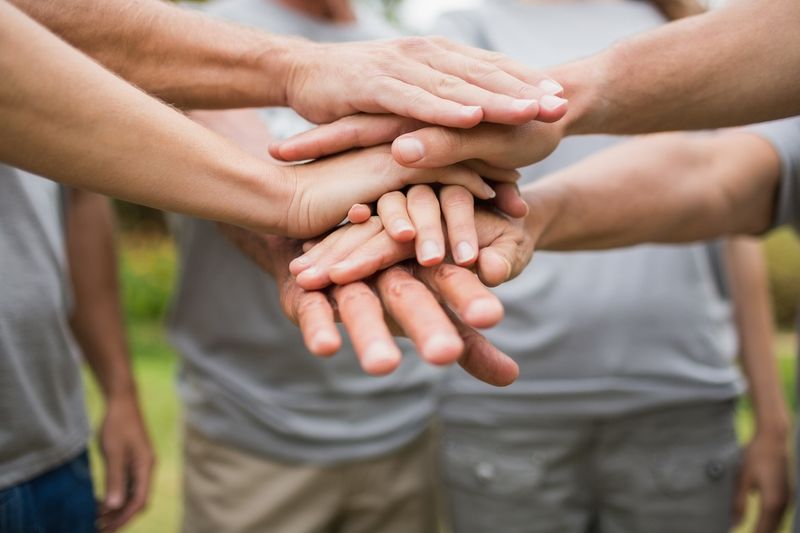 Menschen legen Hände übereinander 