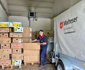 Alfred Hau, Koordinator Auslandsdienst der Malteser im Bistum Fulda steht inmitten der Hilfsgüter für die Ukraine. Foto: Verena Quell