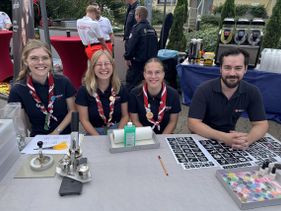 Mitglieder der Malteser Jugend sitzen am Tisch und lächeln in die Kamera