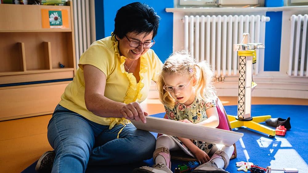 Eine Frau spielt mit einem Kind.