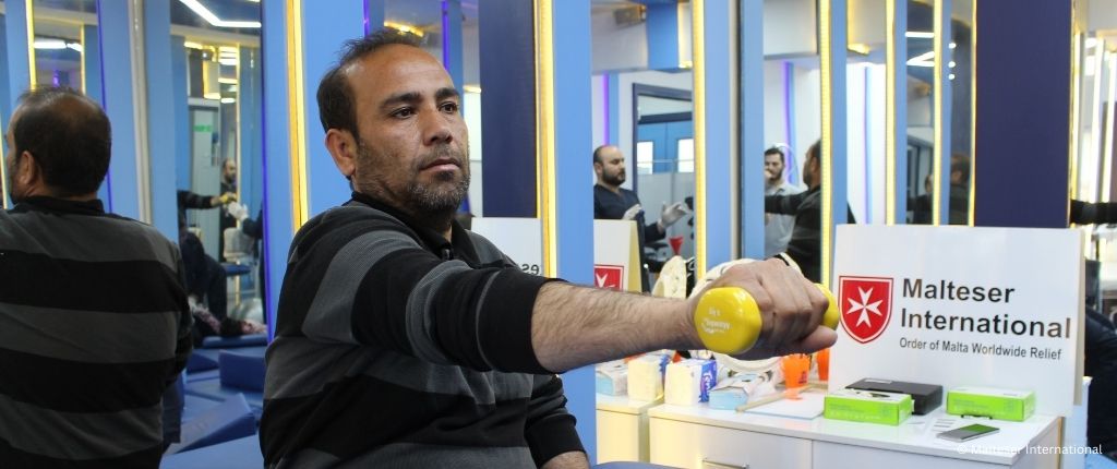 Man performing rehabilitation movements in Malteser International supported clinic.