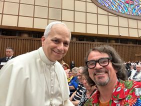 Ein Pilger macht ein Selfie mit Papst Leo