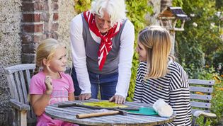 Ein Kind und zwei weitere Personen im Garten
