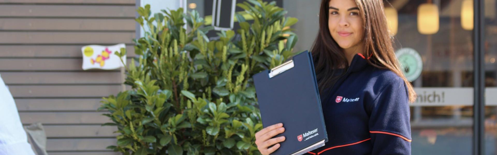 Junge Frau mit Klemmbrett und Einkaufswagen