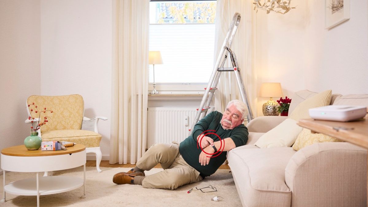 Ein Senior stürzt bei sich zuhause und betätigt den Hausnotruf Notfallknopf.