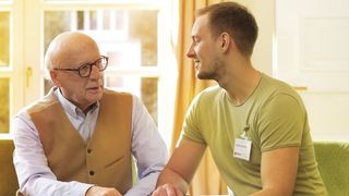 Ein älterer und ein jüngerer Mann im Gespräch.