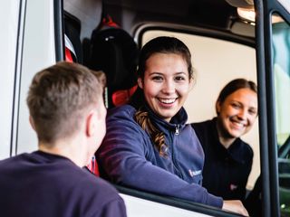 Junge Leute sitzen in einem Malteser Auto