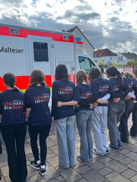 Schulsanitäter geschlossen vor dem Rettungswagen