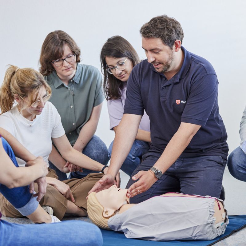 Ausbilder zeigt das Kopf-Überstrecken an einem Übungspahntom