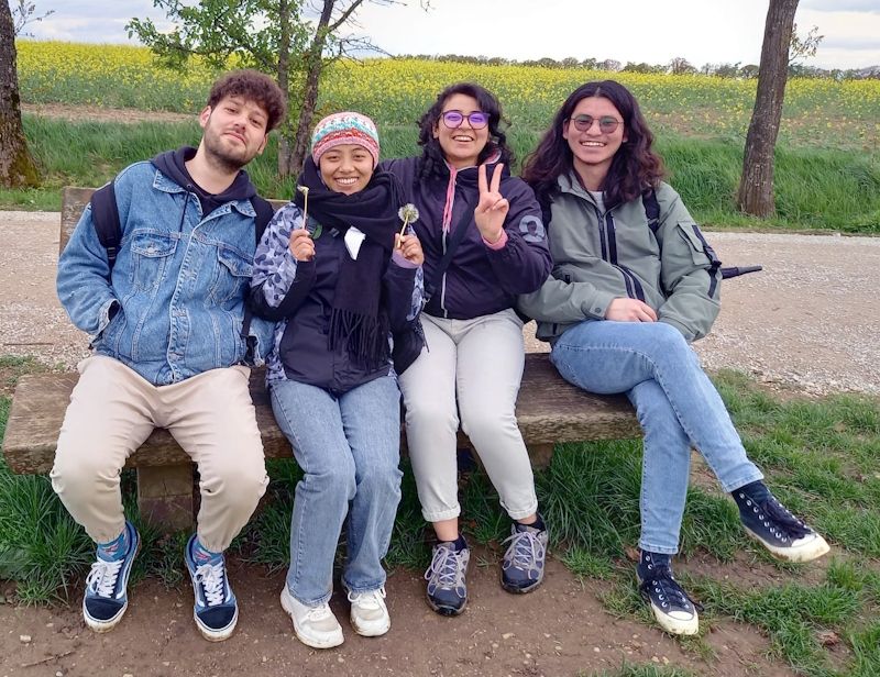 Vier Pflege-Azubis sitzen auf einer Bank