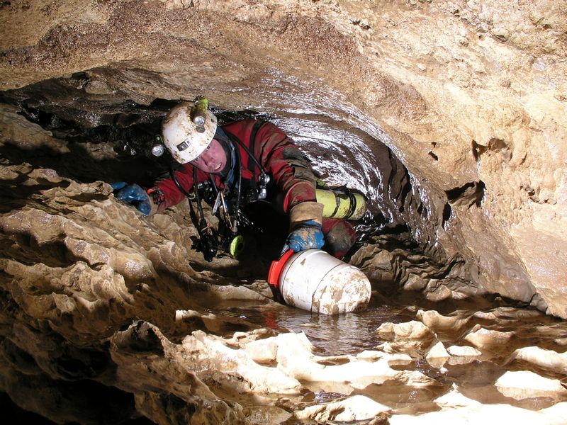 Höhlenretter kriecht durch den Tunnel