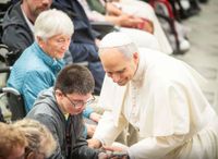 Der Papst im Kontakt mit einem Jungen, der im Rollstuhl sitzt