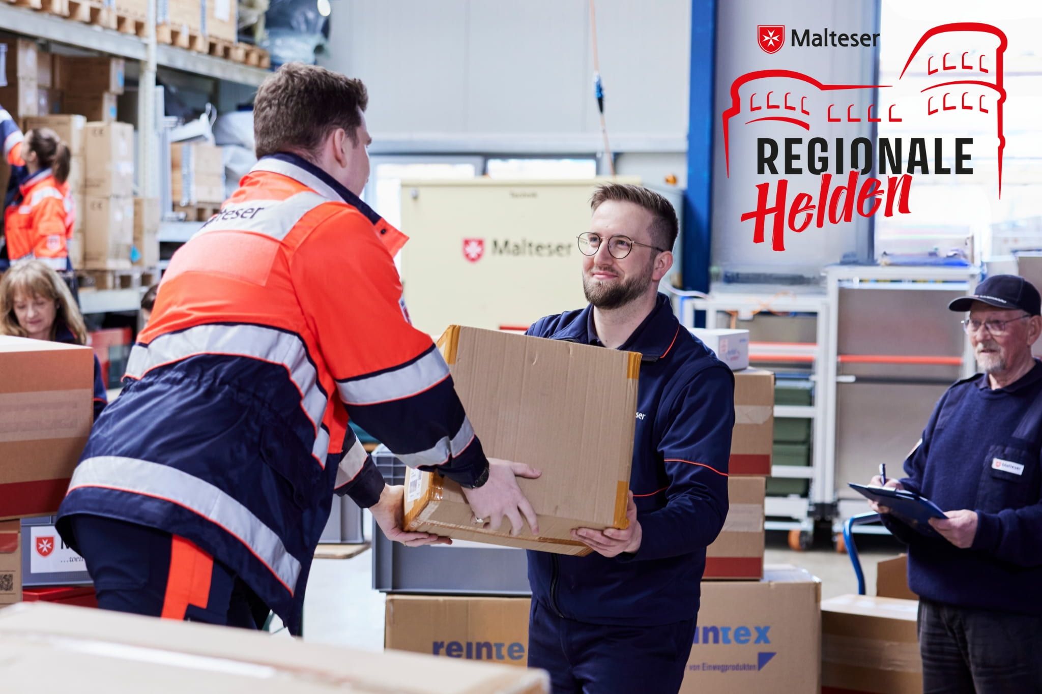 Simon nimmt einen Karton bei der Vorbereitung eines Hilfsgütertransportes entgegen