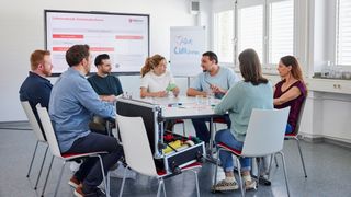 Sieben junge Erwachsene sitzen beim Malteser Erste-Hilfe-Kurs für Fortbildungszwecke zusammen.