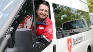 Fahrer des Malteser Fahrdienstes schaut aus dem Autofenster.