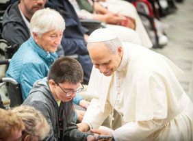 Der Papst im Kontakt mit einem Jungen, der im Rollstuhl sitzt