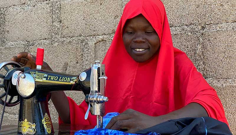 Eine Frau sitzt an einer Nähmaschine