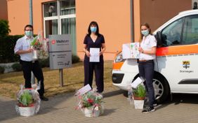 Barbara Caron (mitte), Hausleitung des Malteserstift St. Katharina freut sich über die Bilder und Blumenschalen für ihre Bewohnerinnen und Bewohner, die Martin Euler und Celina Kullmann überreichten. Fotos: Malteser Dormagen