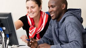 Ein Mann und eine Frau sitzen gemeinsam an einem Laptop.